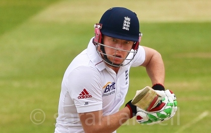 Jonny Bairstow holding a cricket bat and looking at something